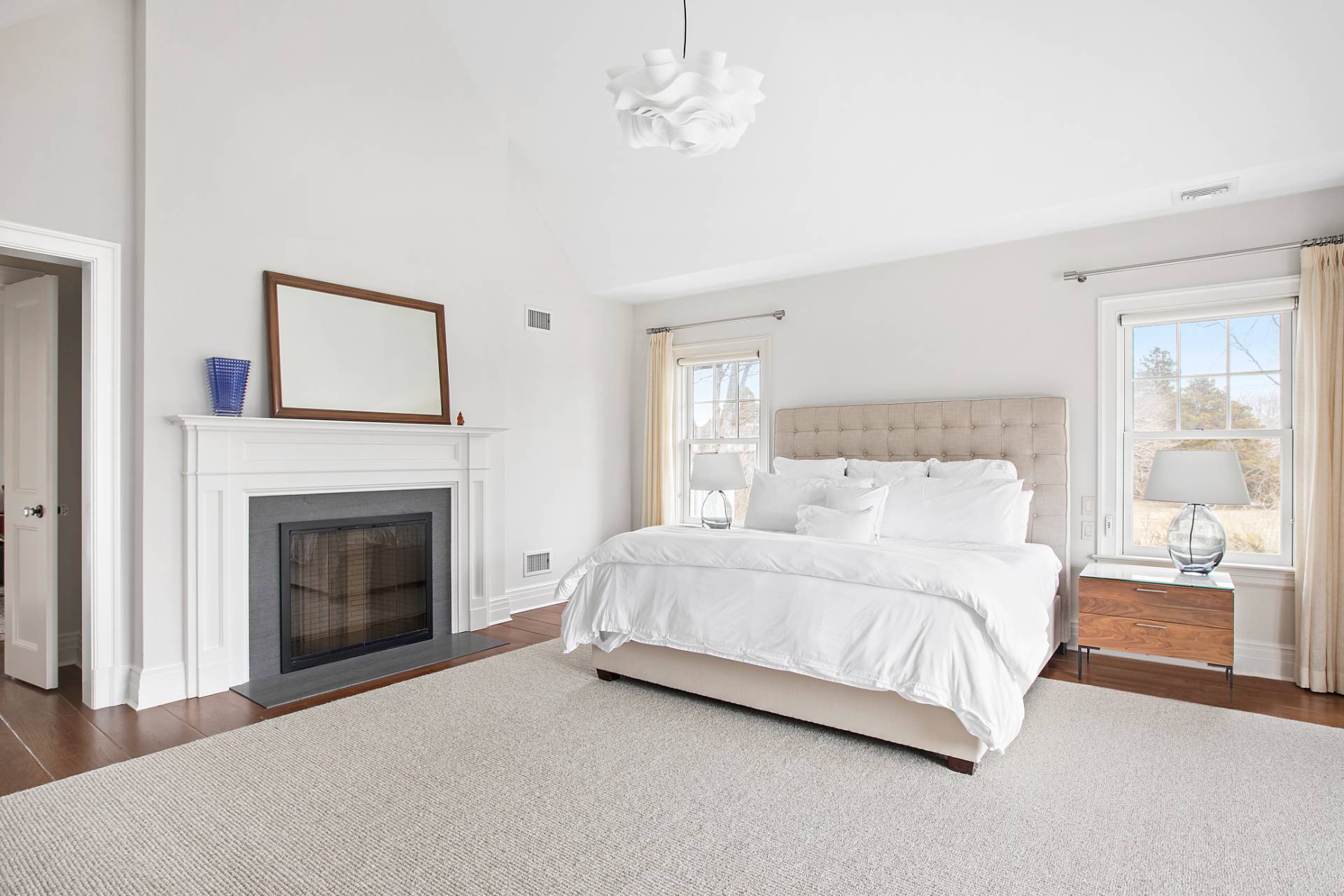 Undisclosed Address Water Mill, NY 11976 - Photo 9 of 26 a bedroom with a large bed and a fireplace