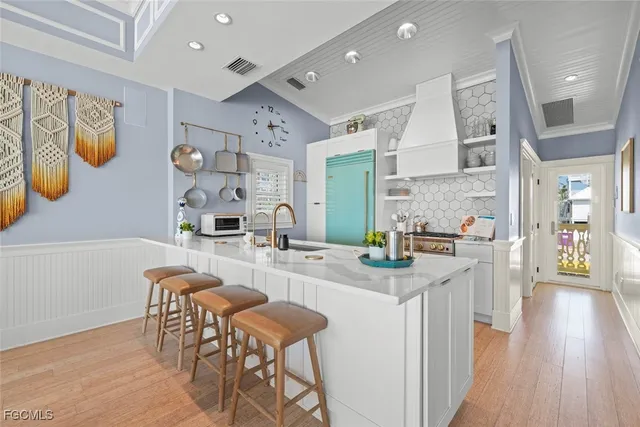 a kitchen with stainless steel appliances granite countertop a table chairs and a refrigerator