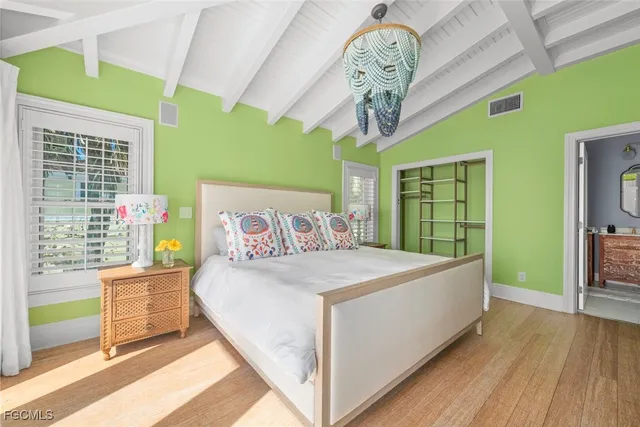 a bedroom with a large bed and a chandelier