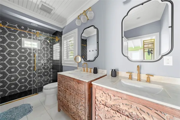 a bathroom with a double vanity sink mirror and toilet