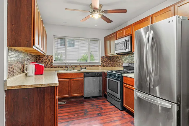 a kitchen with stainless steel appliances granite countertop a refrigerator and a stove top oven