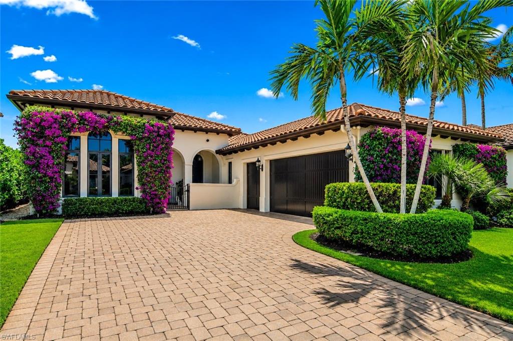 2220 Residence Circle Naples, FL 34105 - Photo 2 of 50 a front view of a house with a garden