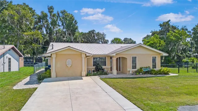 a front view of a house with a yard and trees
