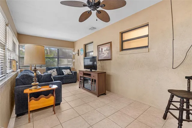 a living room with furniture a flat screen tv and a window