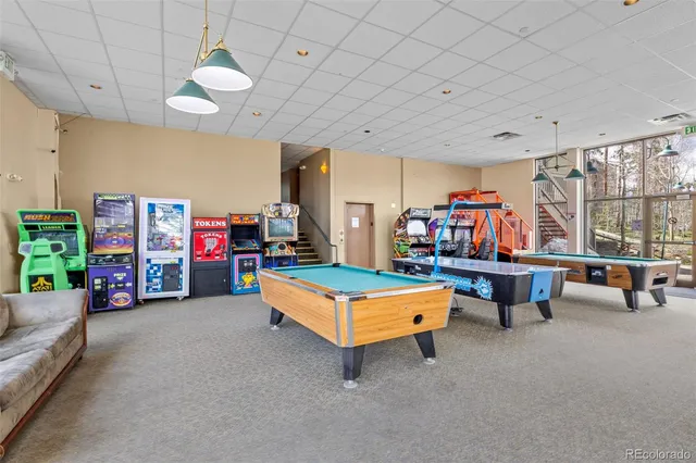 a living room with furniture a pool table and a large window