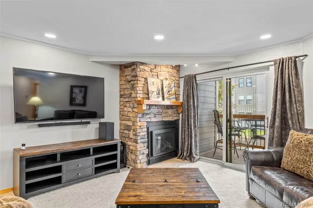 a living room with furniture a flat screen tv and a fireplace
