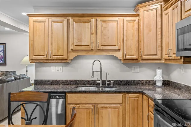 a kitchen with stainless steel appliances granite countertop a stove a sink and a microwave