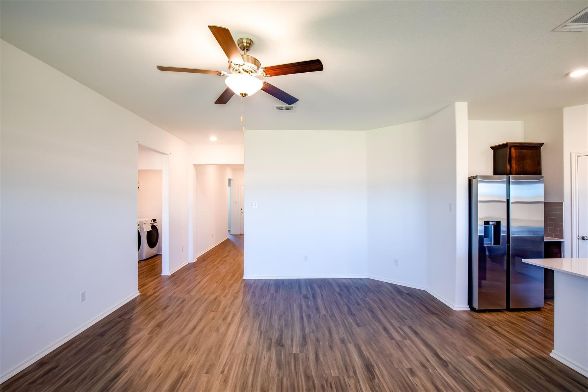 614 Milliner Loop Hutto, TX 78634 - Photo 23 of 25 A versatile open-concept living area boasts durable flooring and recessed lighting, ready for personalization.