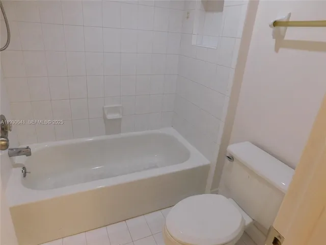 a white bath tub sitting next to a white toilet