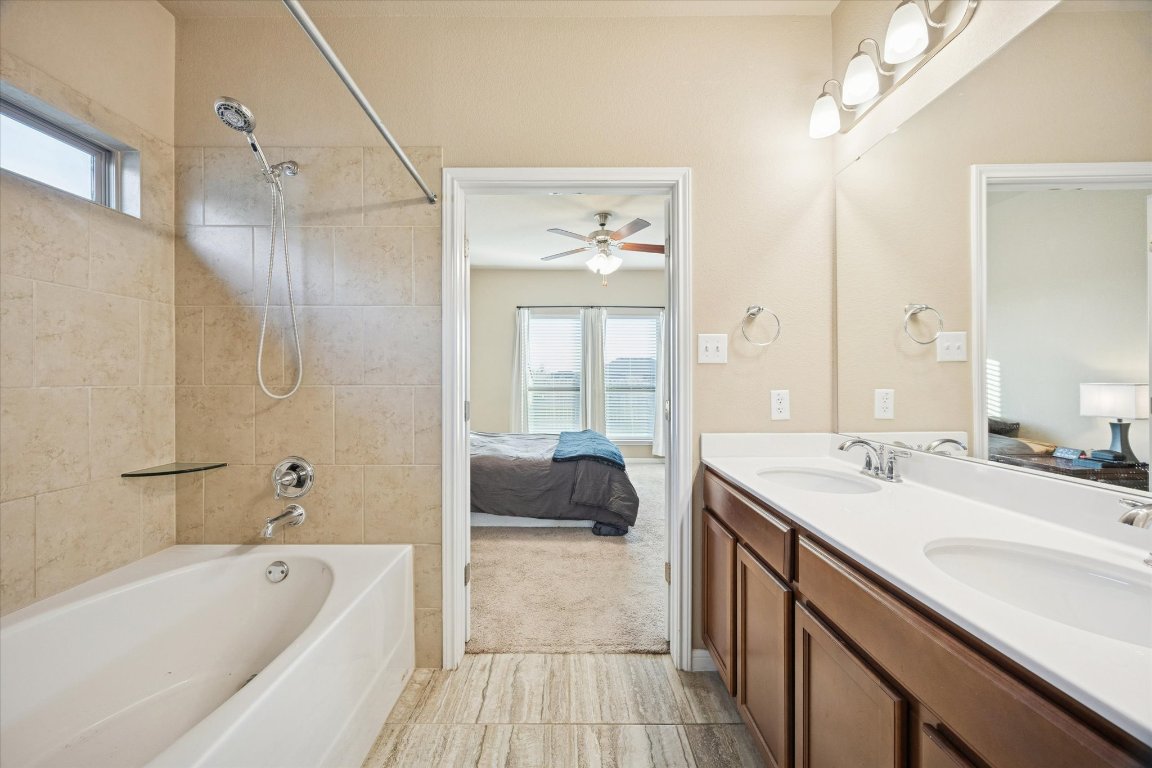 7517 Hickman Street Temple, TX 76502 - Photo 8 of 16 a bathroom with a tub a double vanity sink and mirror