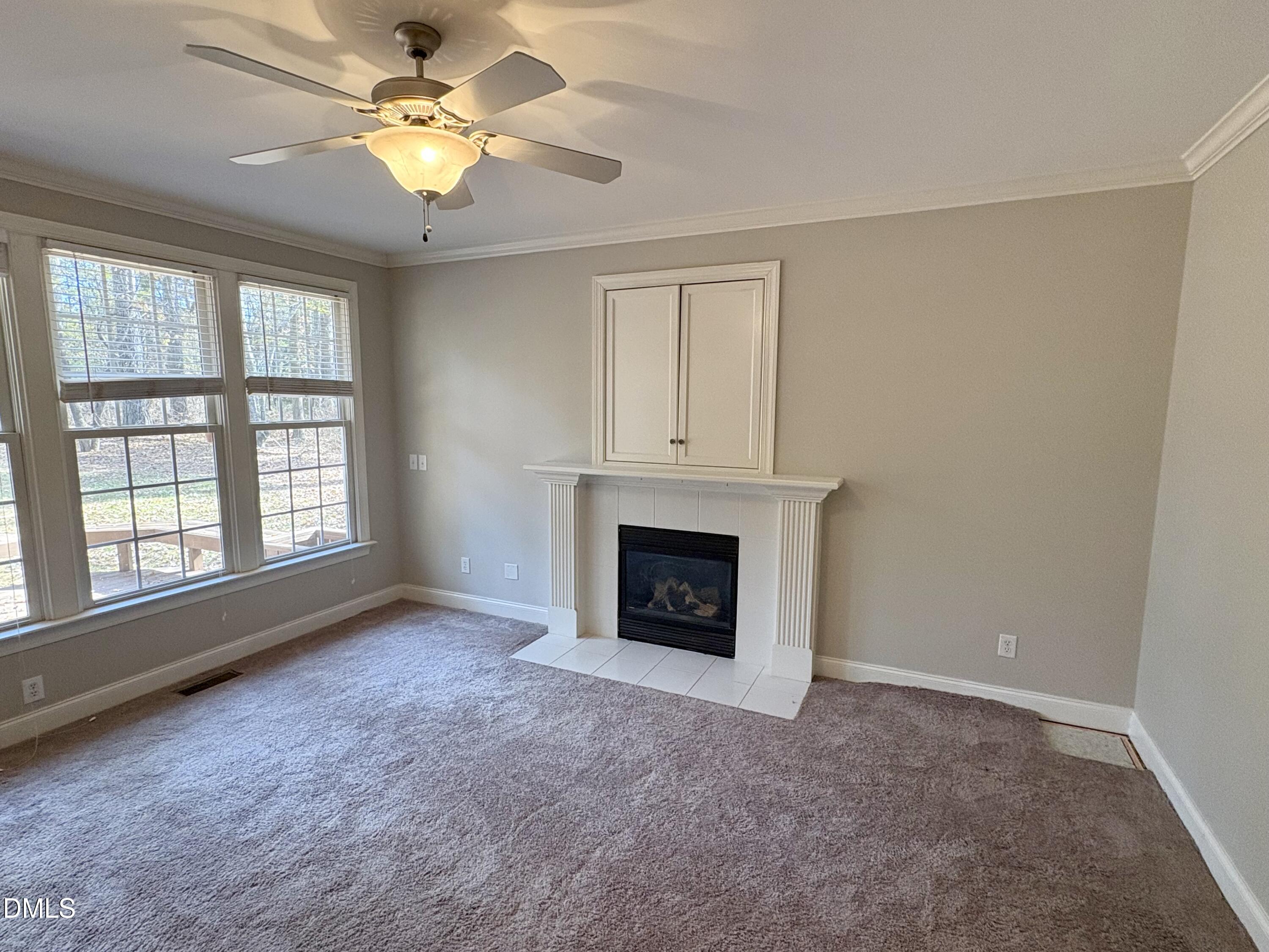 3304 Drexel Hill Court Apex, NC 27539 - Photo 6 of 20 an empty room with windows and fireplace ceiling fan