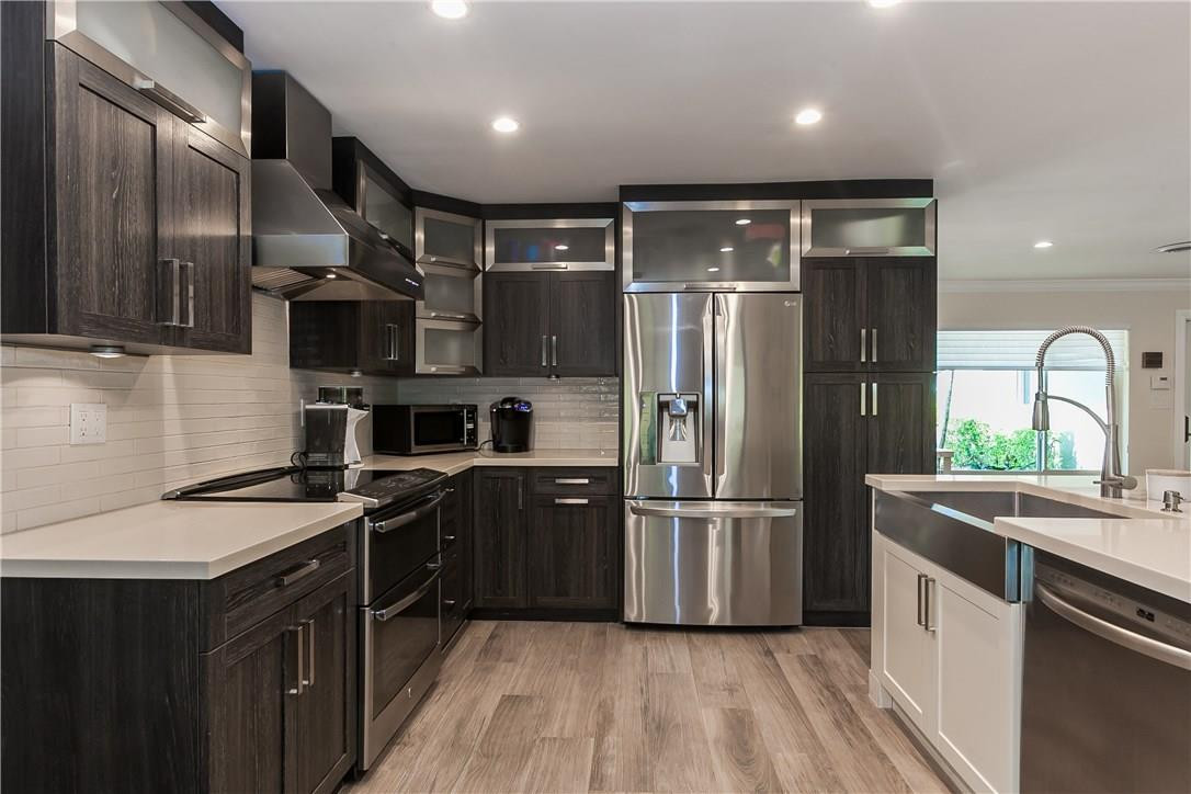 1260 Southwest 4th Street Boca Raton, FL 33486 - Photo 7 of 21 a kitchen with stainless steel appliances granite countertop a sink stove and refrigerator