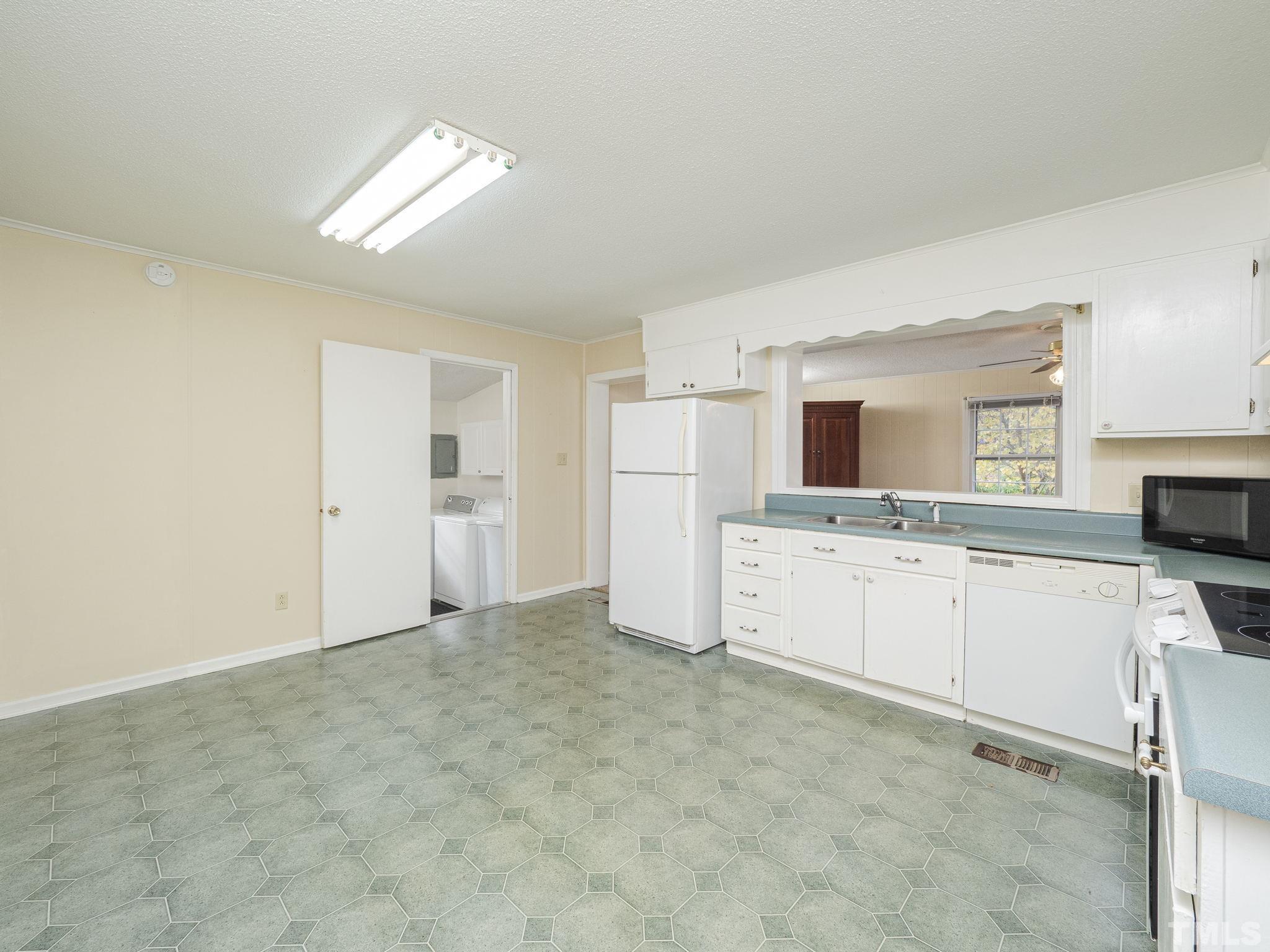 6400 Buffaloe Road Raleigh, NC 27604 - Photo 5 of 25 a view of a kitchen with white cabinets and white appliances