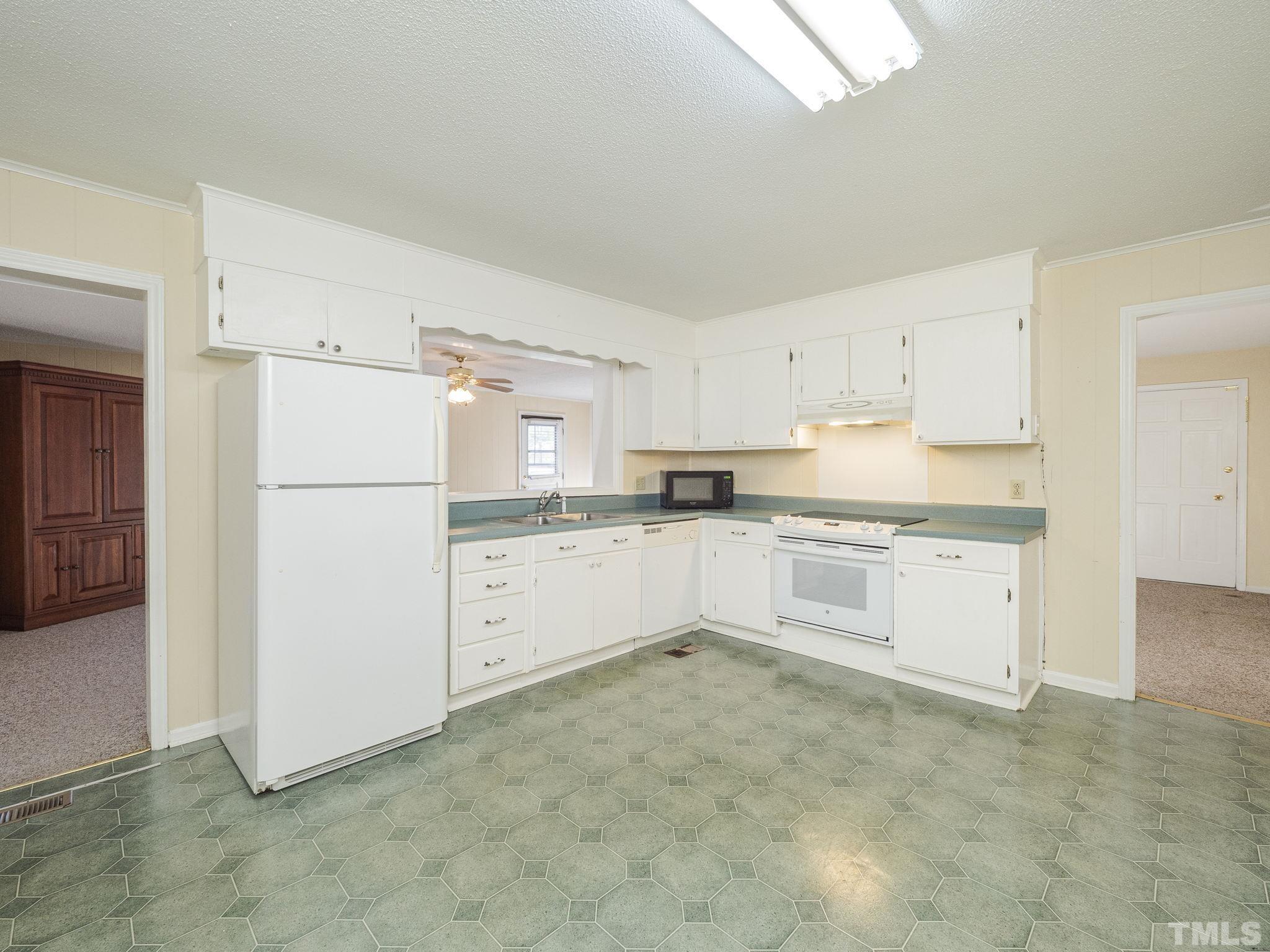 6400 Buffaloe Road Raleigh, NC 27604 - Photo 6 of 25 a kitchen with white cabinets and white appliances