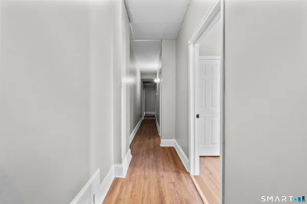 a view of a hallway with wooden floor