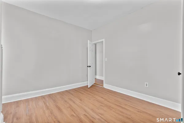 a view of an empty room with wooden floor
