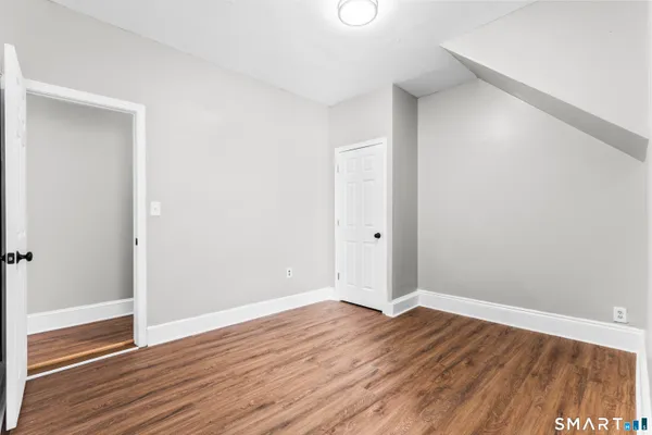 a view of an empty room with wooden floor