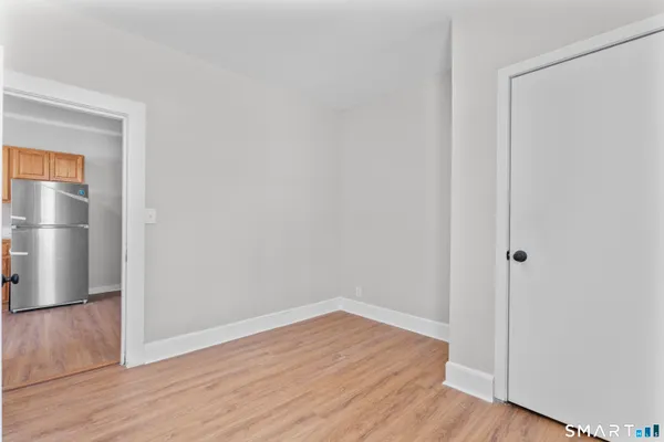 a view of empty room with wooden floor