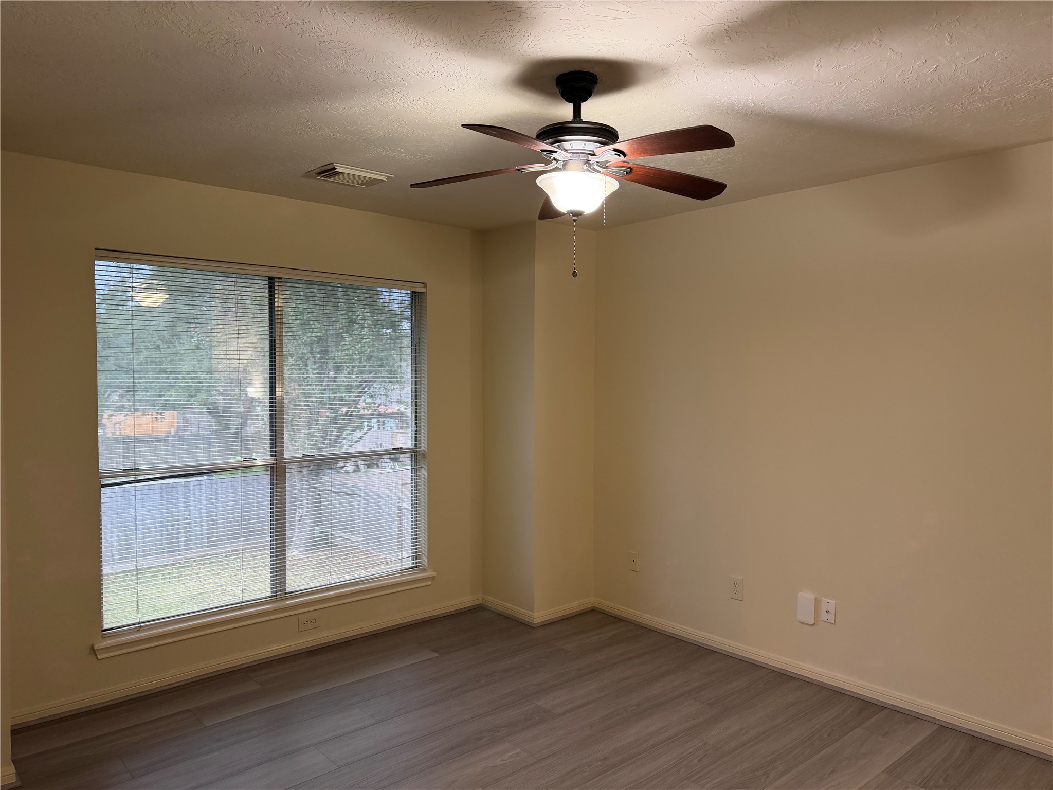 4738 Stoney Point Court Sugar Land, TX 77479 - Photo 14 of 20 an empty room with wooden floor fan and windows