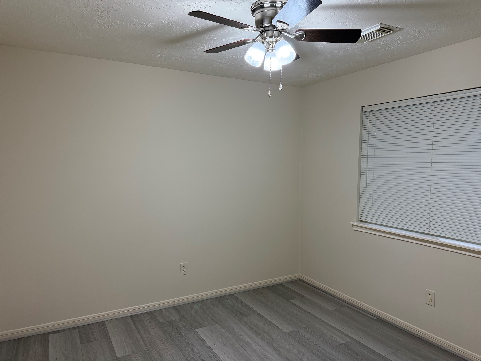 4738 Stoney Point Court Sugar Land, TX 77479 - Photo 15 of 20 an empty room with a chandelier fan and wooden floor