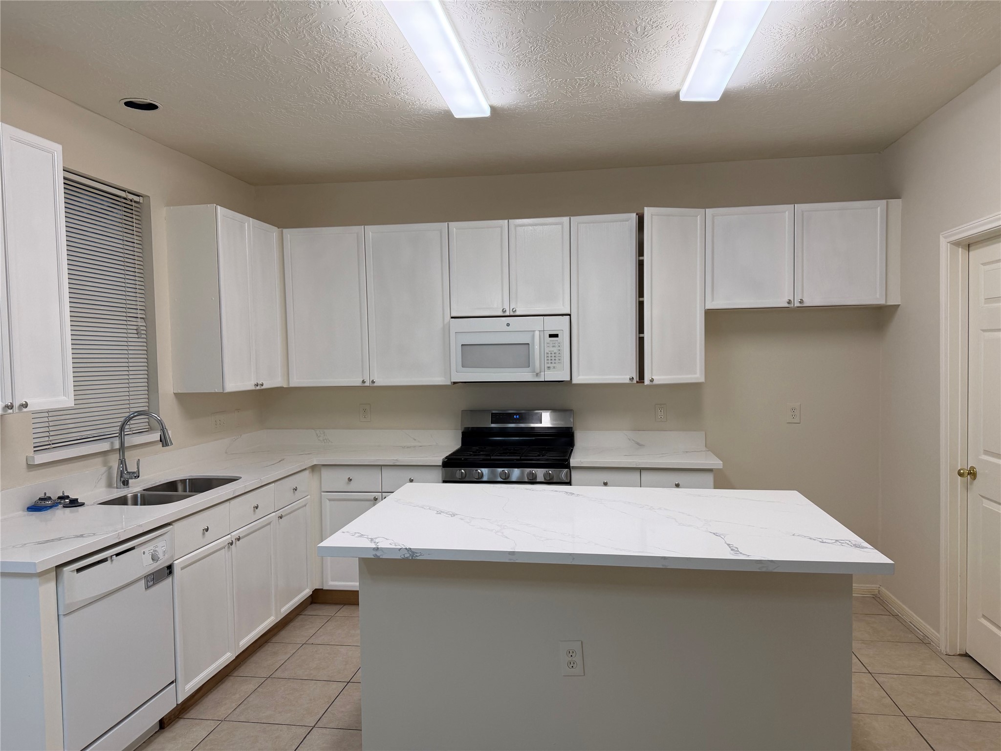 4738 Stoney Point Court Sugar Land, TX 77479 - Photo 4 of 20 a kitchen with a sink a stove a refrigerator and cabinets