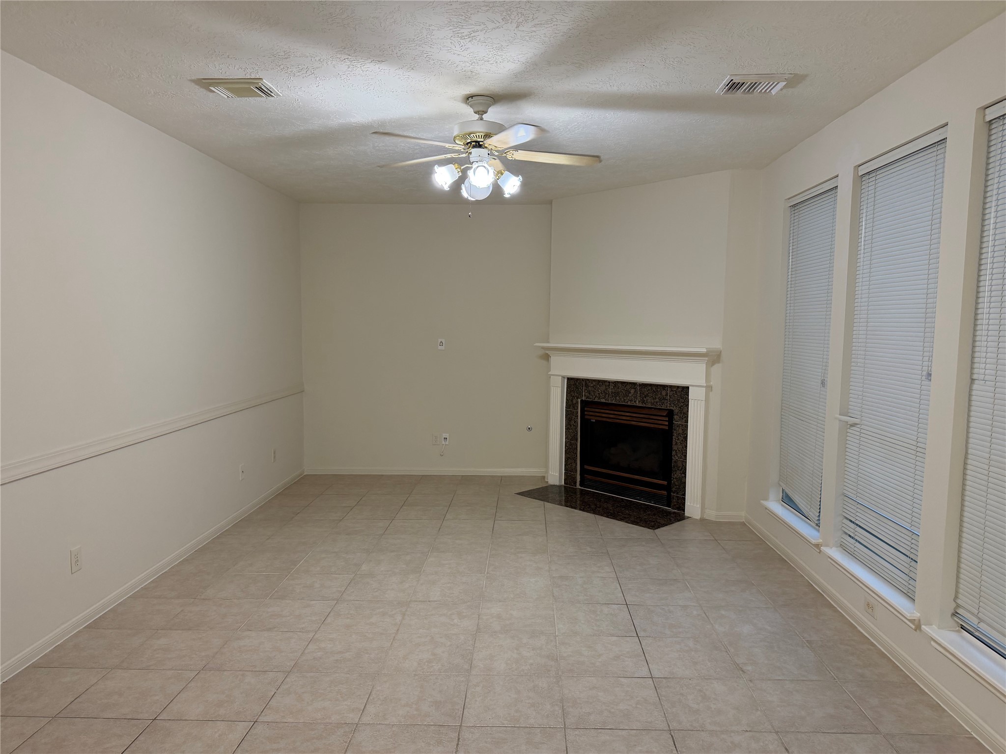4738 Stoney Point Court Sugar Land, TX 77479 - Photo 6 of 20 an empty room with a fireplace and chandelier fan