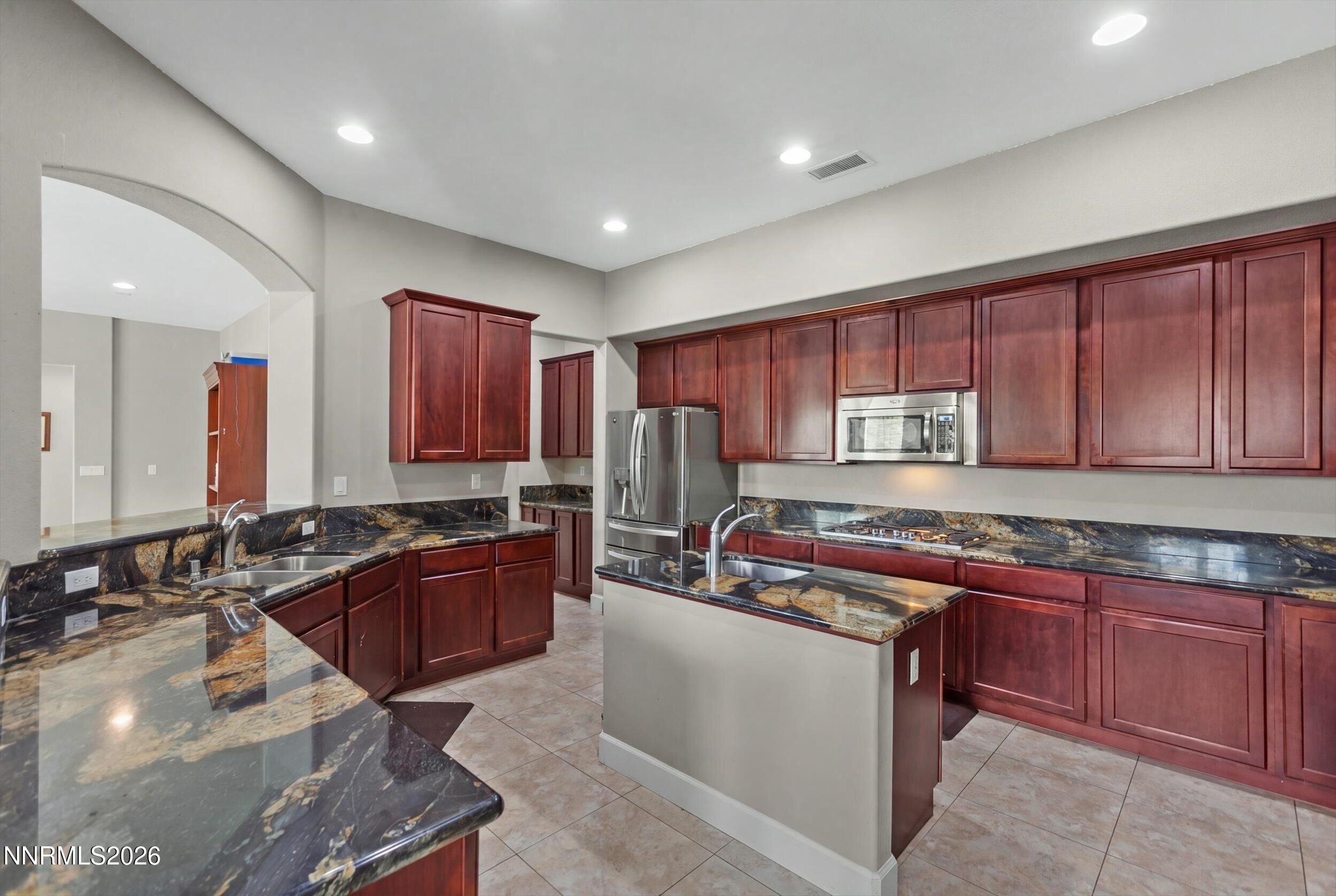 2920 Bull Rider Drive Reno, NV 89521 - Photo 11 of 51 a kitchen with stainless steel appliances granite countertop wooden cabinets a sink dishwasher a stove and a refrigerator