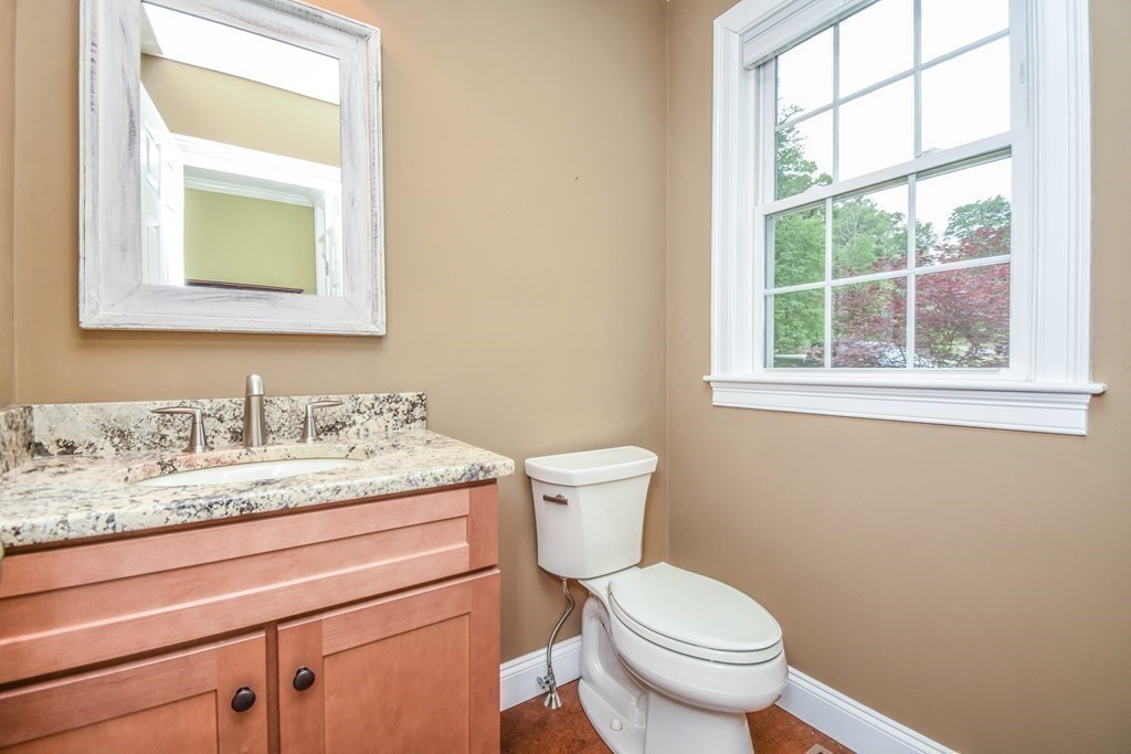 77 Dudley Road, Unit 77 Berlin, MA 01503 - Photo 12 of 30 a bathroom with a granite countertop toilet sink and mirror