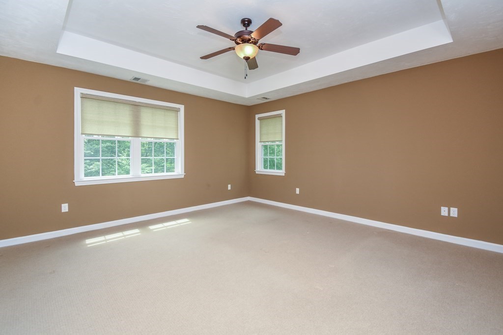 77 Dudley Road, Unit 77 Berlin, MA 01503 - Photo 14 of 30 an empty room with a window and a ceiling fan