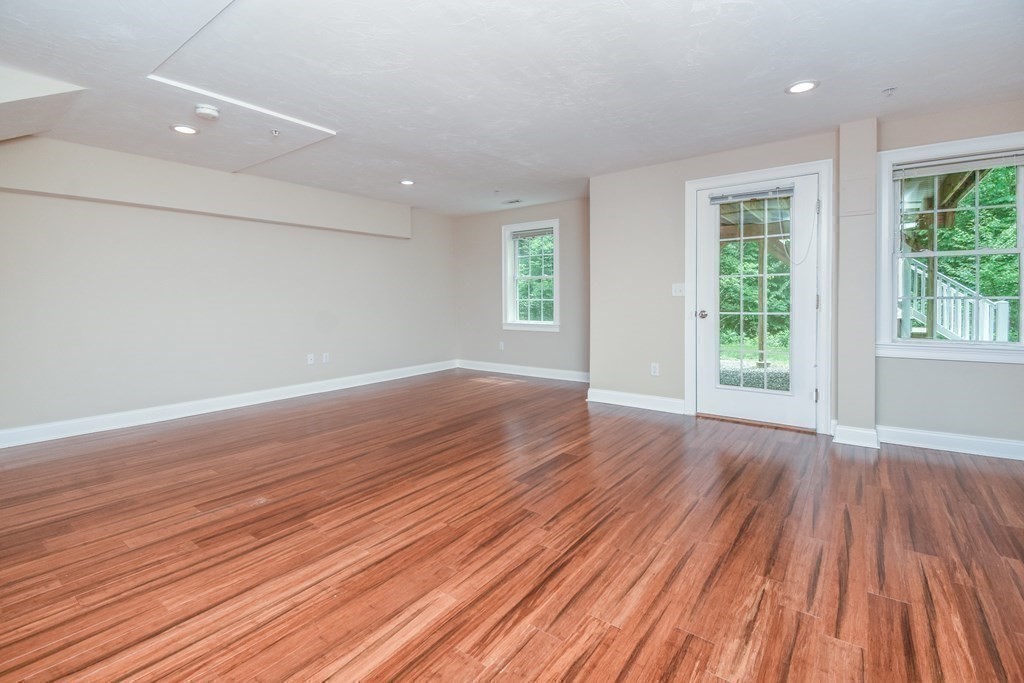 77 Dudley Road, Unit 77 Berlin, MA 01503 - Photo 24 of 30 an empty room with wooden floor and windows