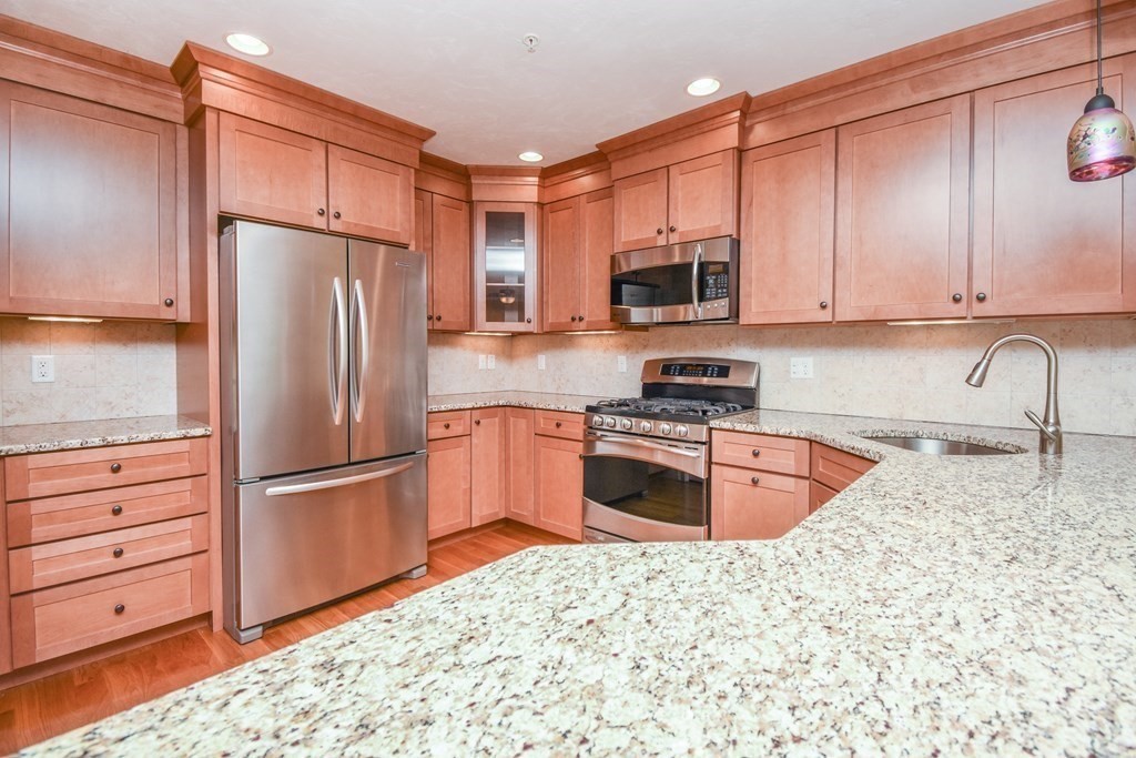 77 Dudley Road, Unit 77 Berlin, MA 01503 - Photo 3 of 30 a kitchen with granite countertop a refrigerator and a stove top oven