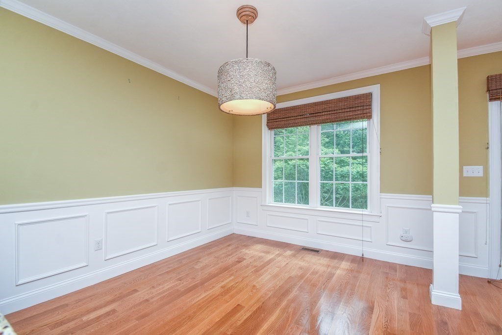 77 Dudley Road, Unit 77 Berlin, MA 01503 - Photo 9 of 30 a view of an empty room with wooden floor and a window
