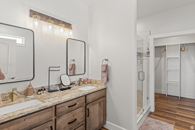 1343 North Trapper Loop Garden City, UT 84028 - Photo 18 of 56 Full bathroom featuring a walk in closet, double vanity, a stall shower, and dark wood finished floors