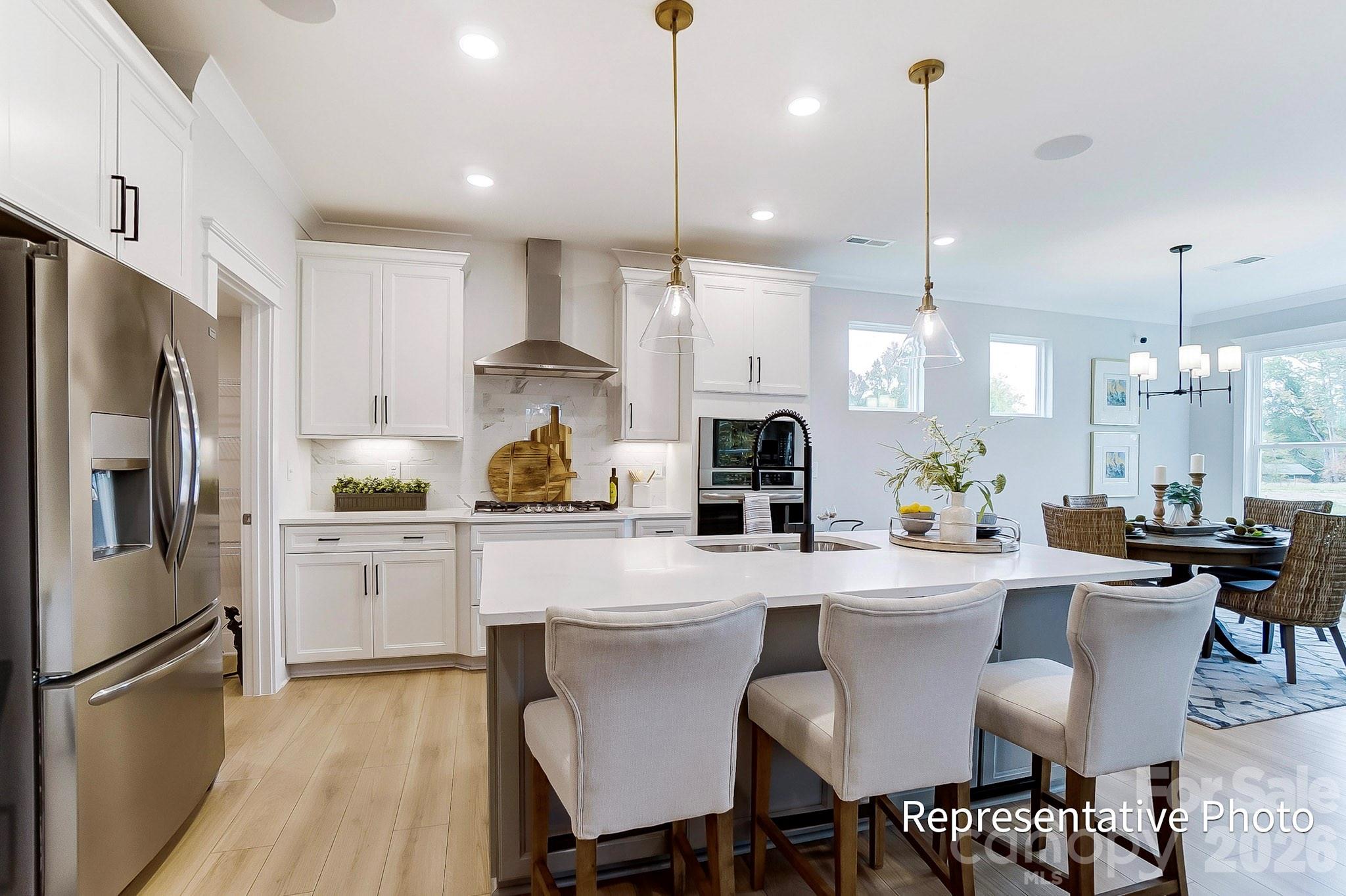 13130 Foxberry Road Charlotte, NC 28213 - Photo 15 of 18 a kitchen with stainless steel appliances kitchen island granite countertop a dining table chairs sink and white cabinets