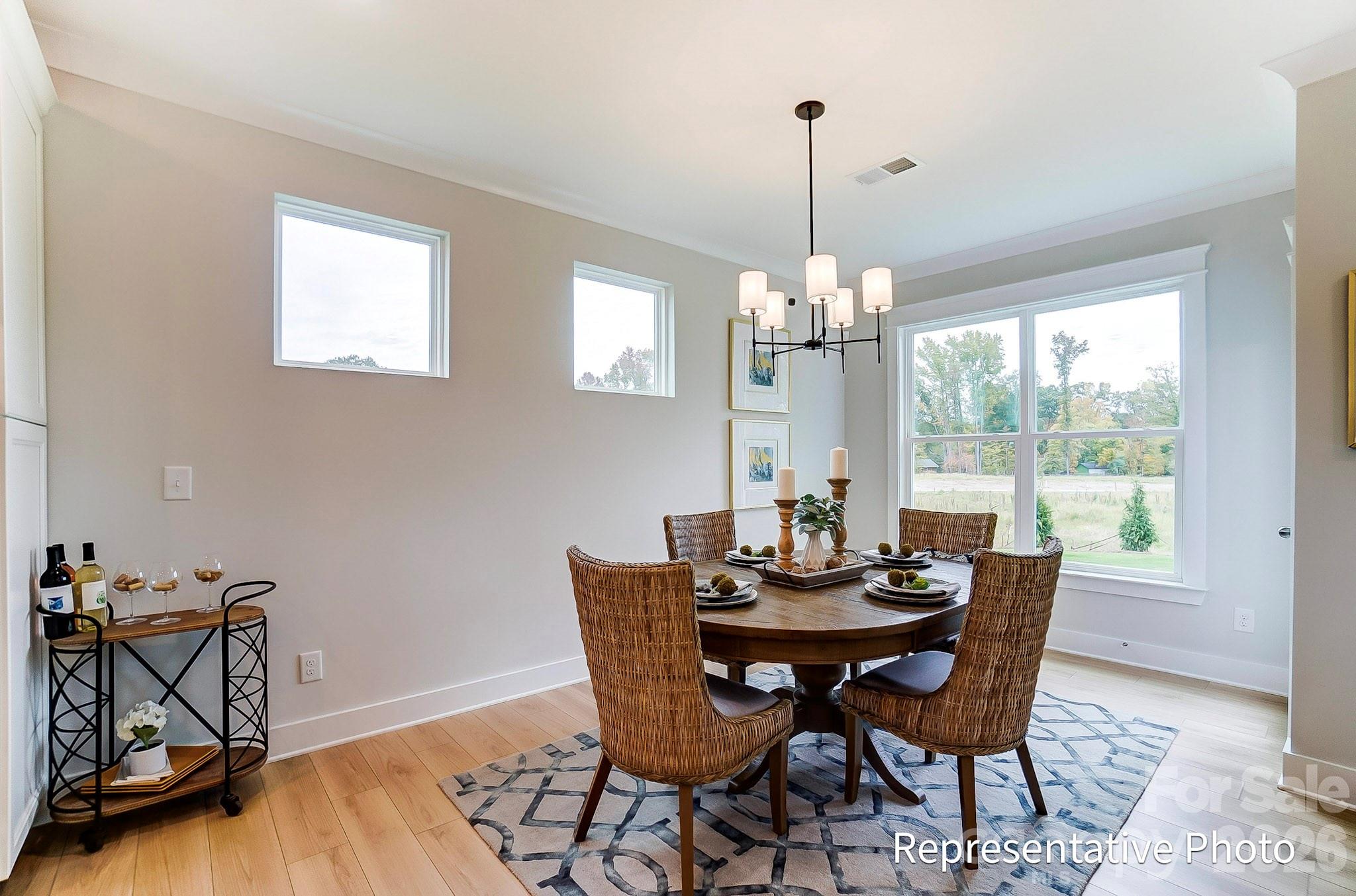 13130 Foxberry Road Charlotte, NC 28213 - Photo 17 of 18 a dining room with furniture a chandelier and wooden floor