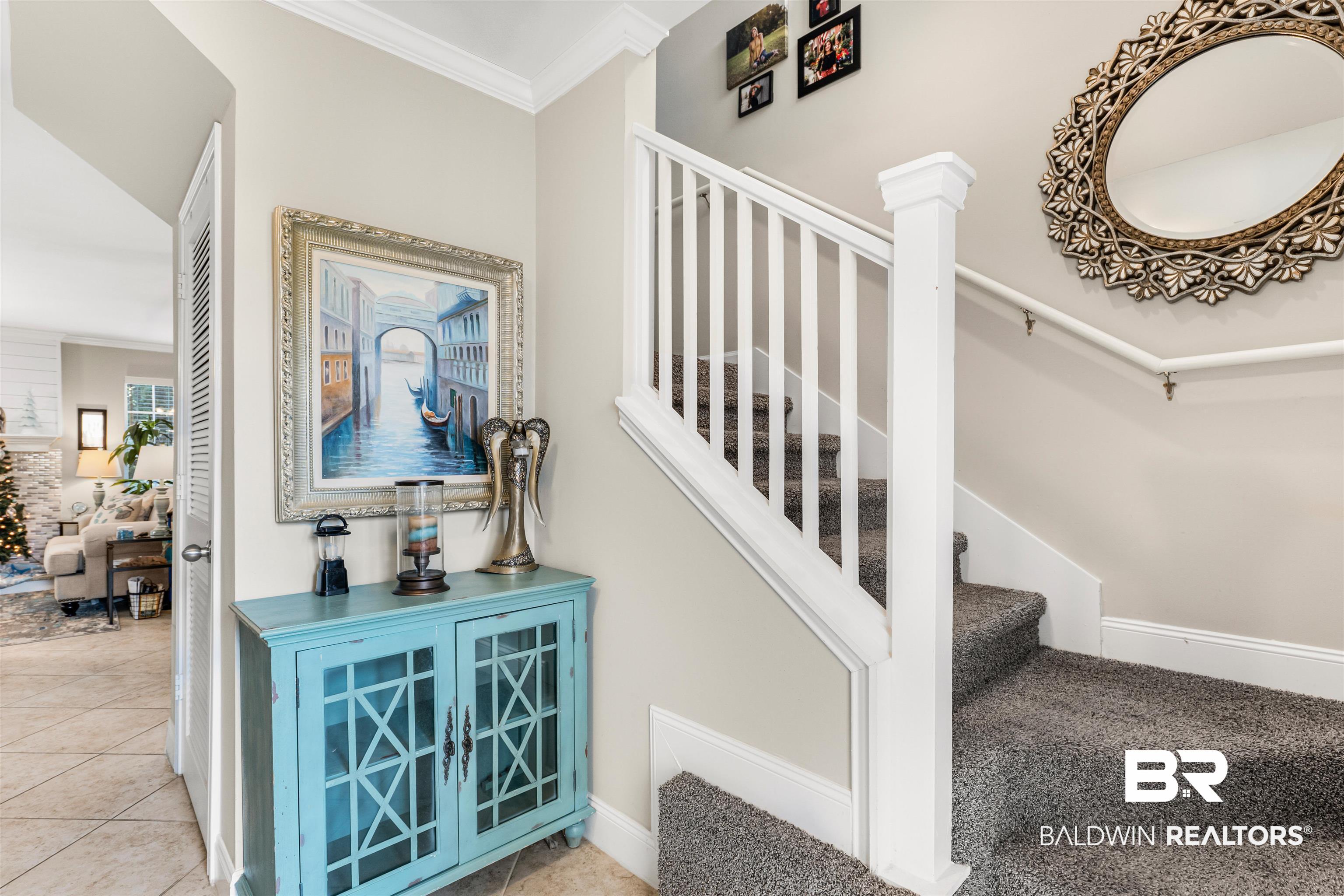 1517 Regency Road, Unit 68 Gulf Shores, AL 36542 - Photo 5 of 43 Stairs with ornate columns, tile patterned flooring, and ornamental molding