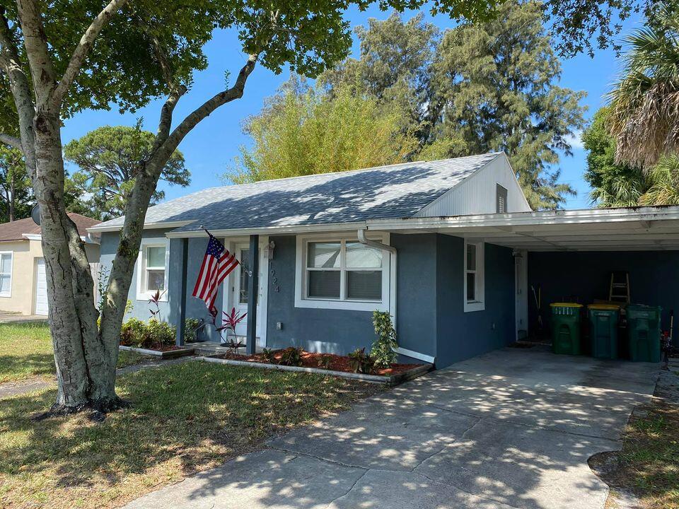 a view of a house with backyard and a tree