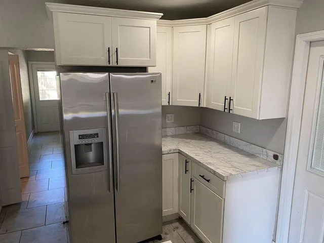 a kitchen with stainless steel appliances granite countertop a refrigerator and a cabinets