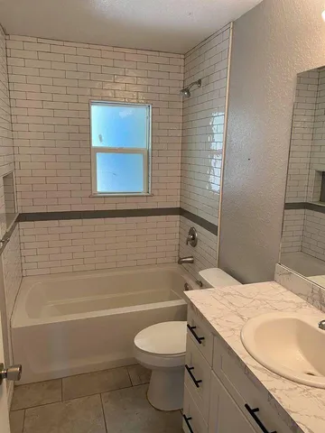 a bathroom with a granite countertop toilet a sink and bathtub