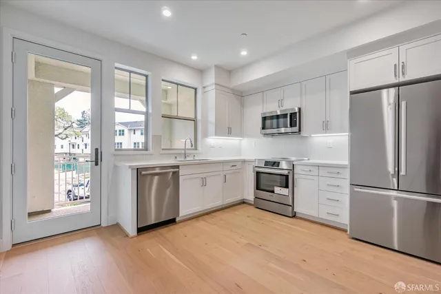 a kitchen with stainless steel appliances granite countertop a refrigerator a stove a sink and a microwave