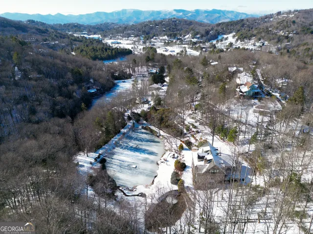 an aerial view of a house with a yard and lake view