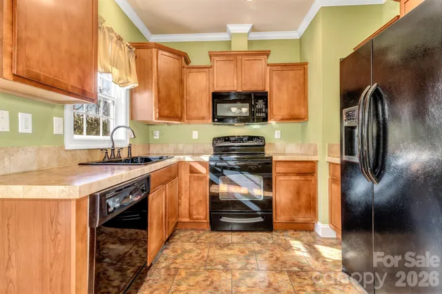 a kitchen with stainless steel appliances granite countertop a sink a stove a refrigerator and cabinets