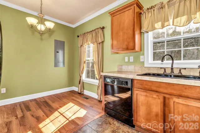 a kitchen that has a lot of cabinets and wooden floor