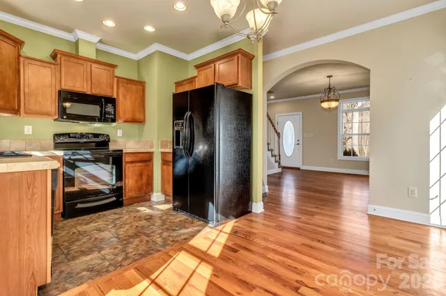 a kitchen with stainless steel appliances granite countertop a refrigerator a stove and a sink