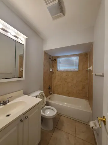 a bathroom with a granite countertop sink a toilet and shower
