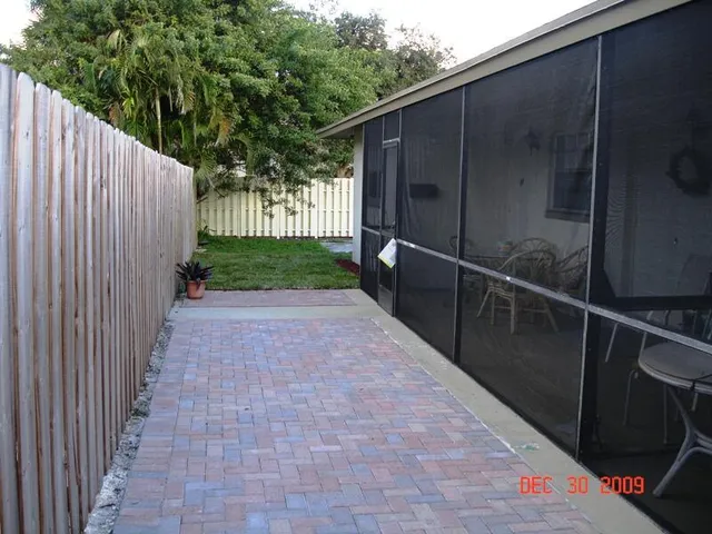 a view of a pathway of a backyard with wooden fence