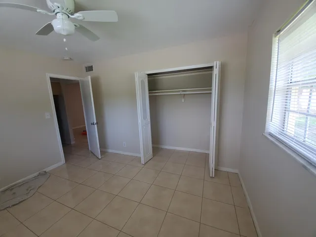 an empty room with closet and a window