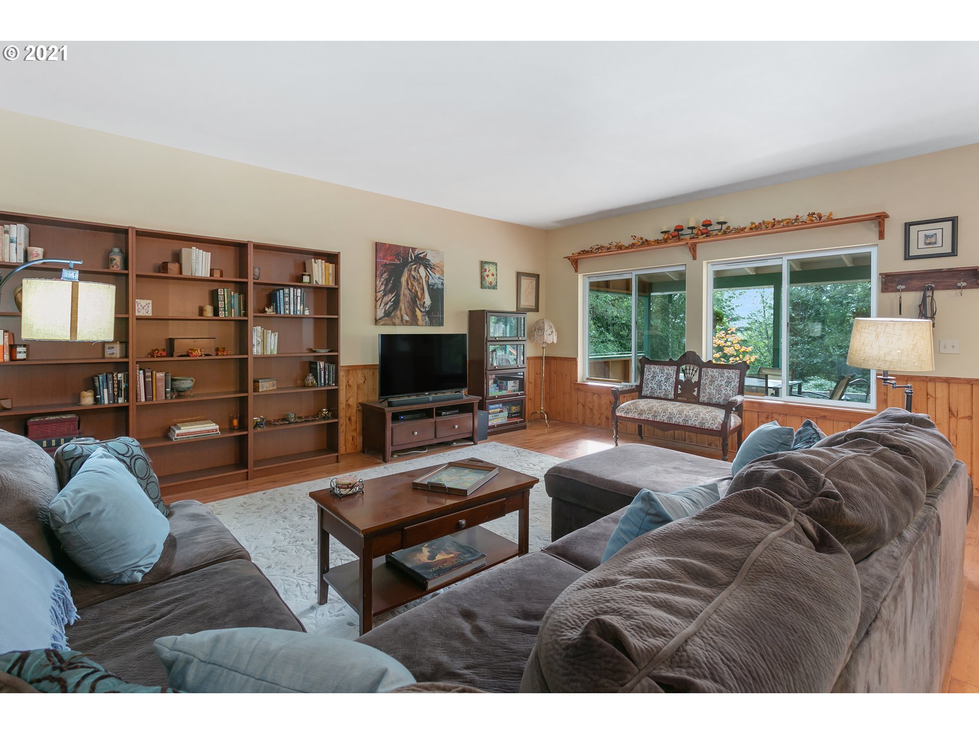 180 Merganser Road Longview, WA 98632 - Photo 13 of 32 a living room with furniture a flat screen tv and a floor to ceiling window