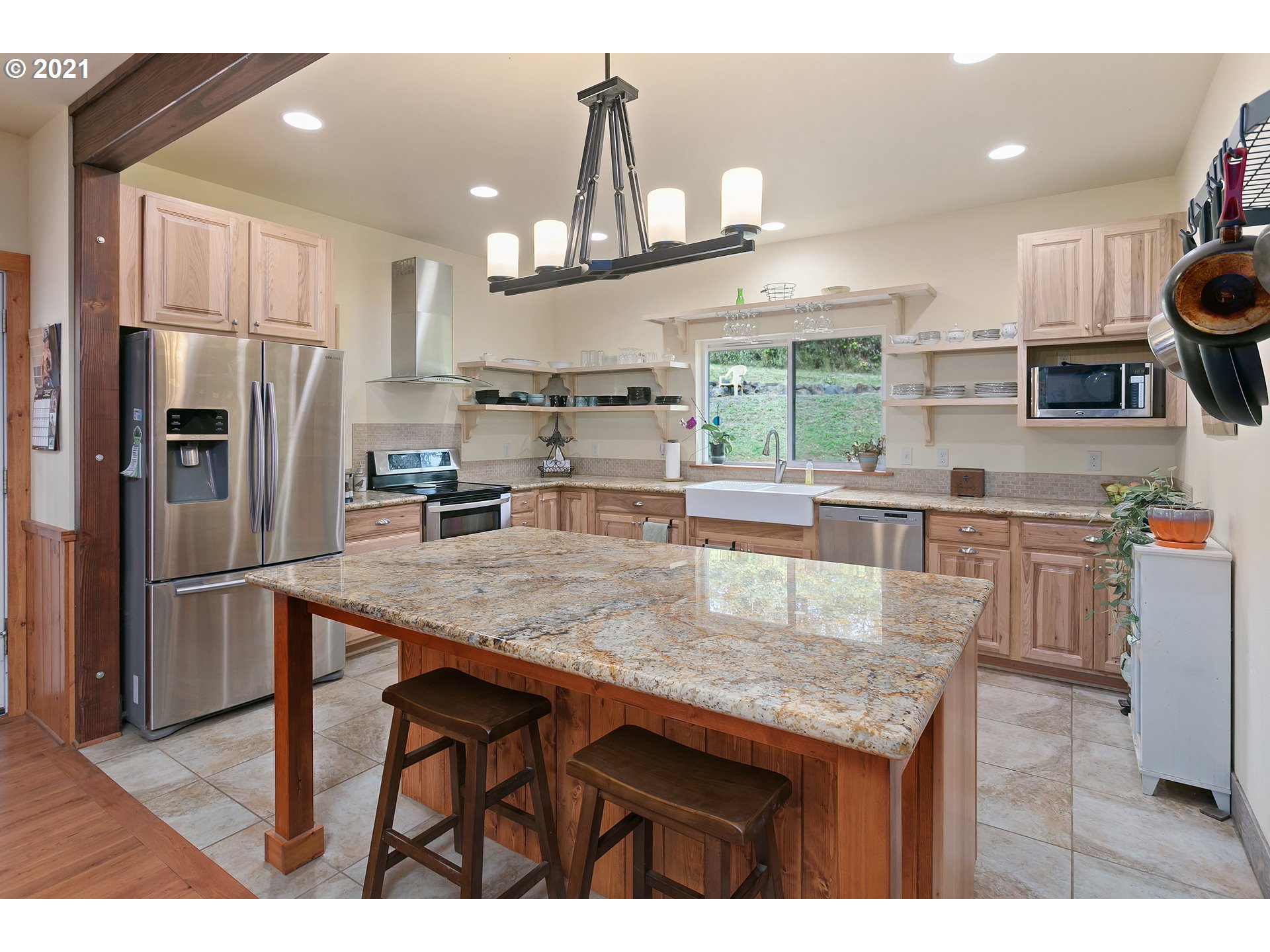 180 Merganser Road Longview, WA 98632 - Photo 5 of 32 a kitchen with stainless steel appliances granite countertop a table chairs and a refrigerator