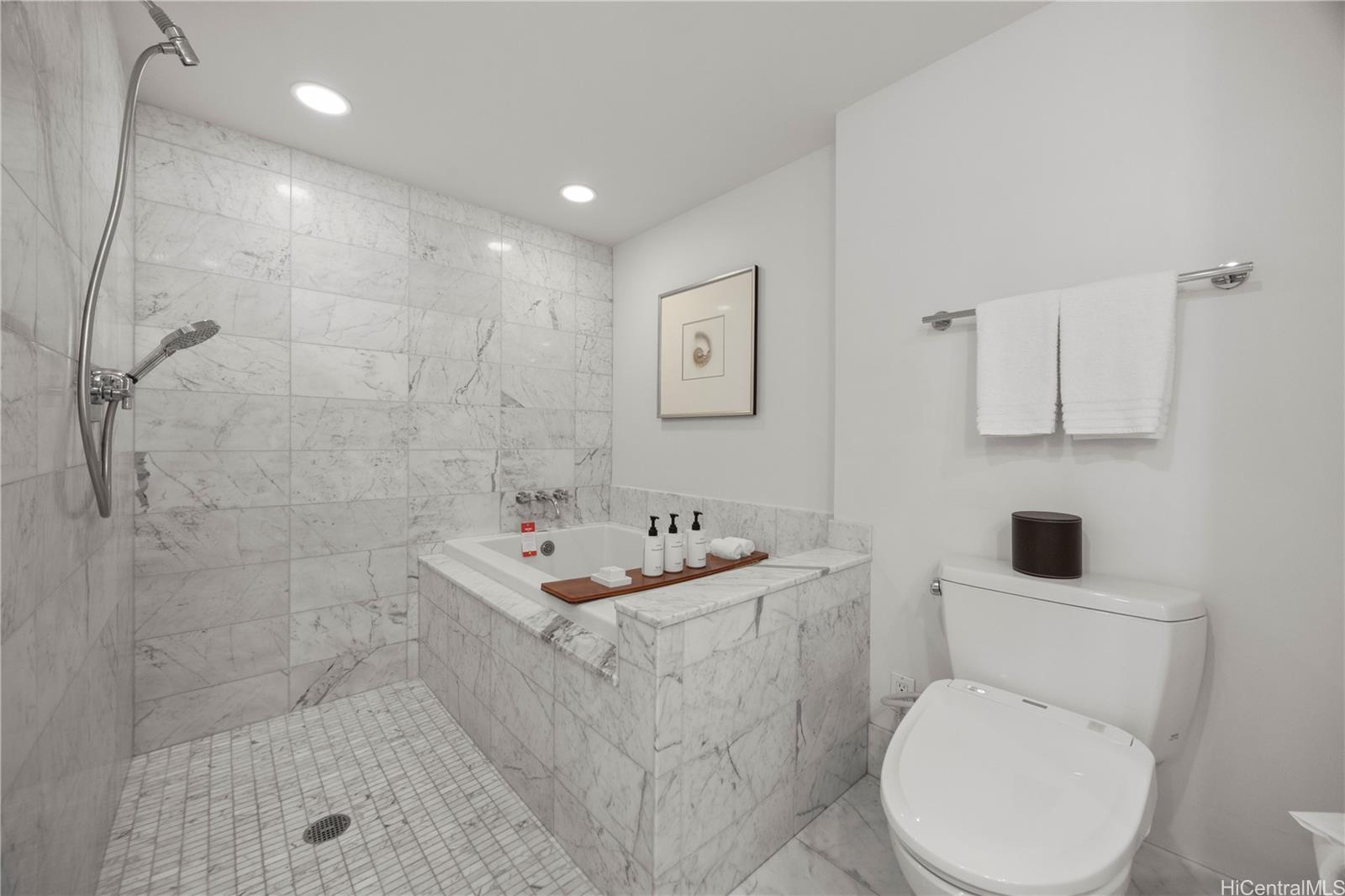 223 Saratoga Road, Unit 1114 Honolulu, HI 96815 - Photo 18 of 23 a bathroom with a toilet sink and mirror